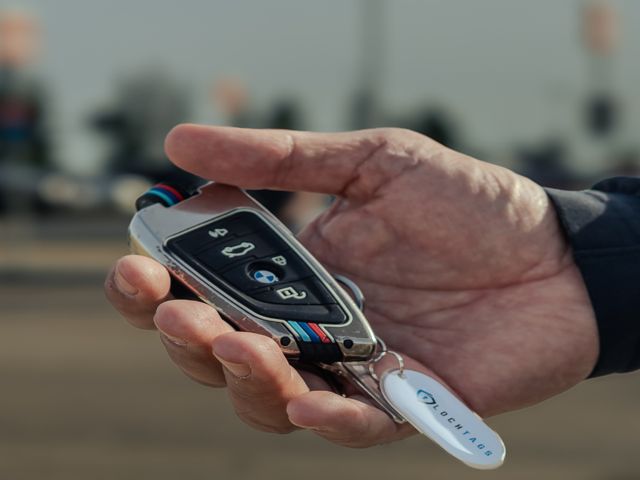 A hand holding keys with a white LochTags tag attached