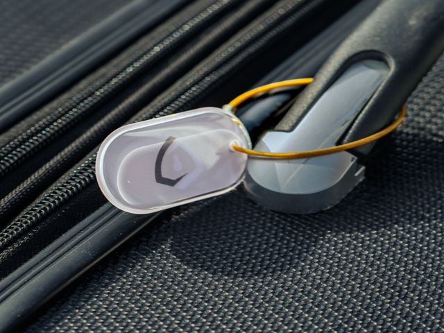 A LochTags tag looped onto a suitcase handle